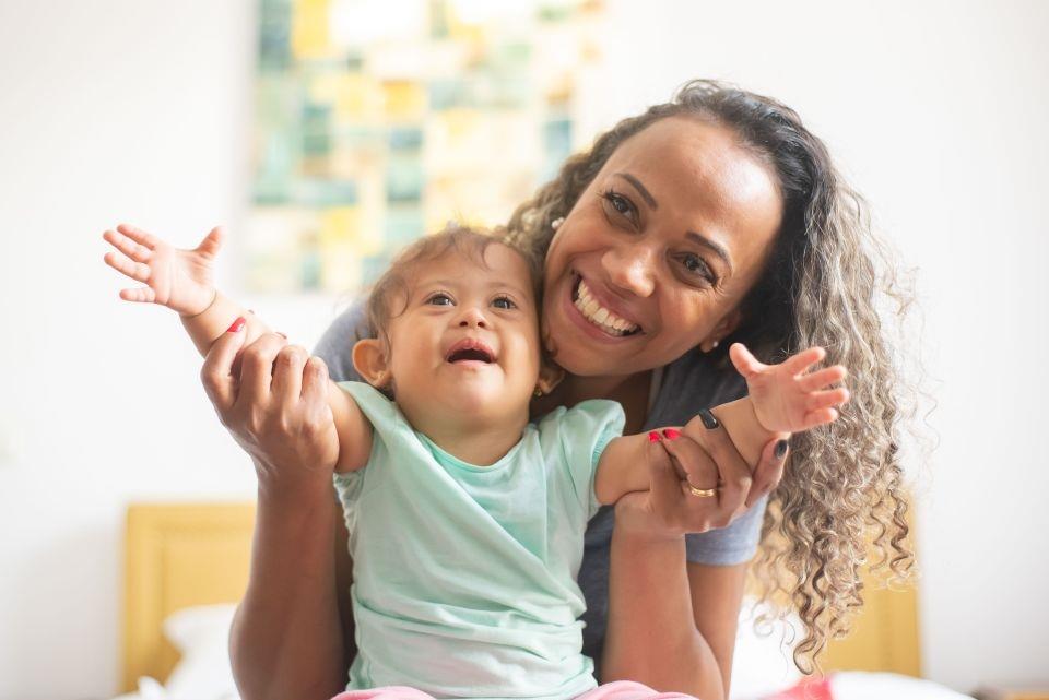 Mother and toddler with arms up